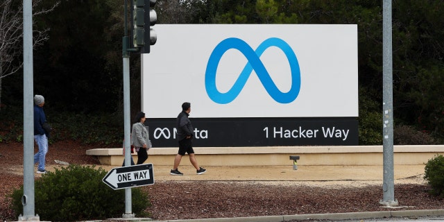 Pengunjung berjalan di depan tanda Meta di kantor pusatnya di Menlo Park, California, 29 Desember 2022.