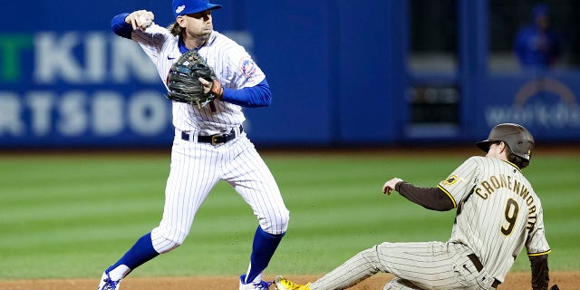 Jeff McNeil of the New York Mets tries to turn a double play against the San Diego Padres during the fourth inning of the second game of the Wild Card Series at Citi Field on October 8, 2022 in New York City.