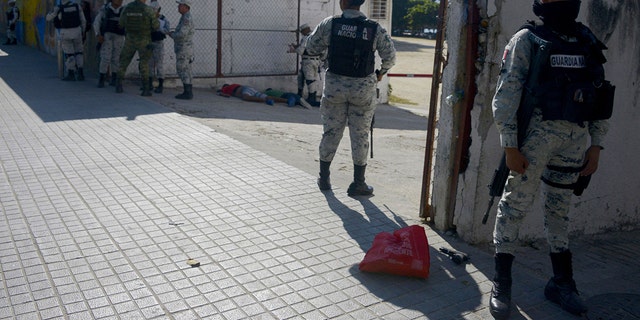 FILE: Members of the Mexican National Guard stand guard the beach area where a man was killed in Acapulco, state of Guerrero, Mexico, on December 5, 2022. 