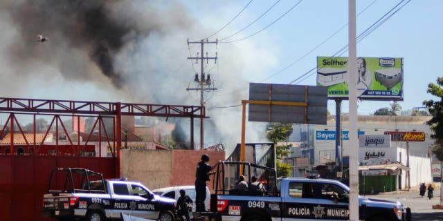 Police arrive on the scene after a store was looted in Culiacan, Sinaloa state, Mexico, on Thursday. Mexican security forces captured Ovidio Guzmán, an alleged drug trafficker wanted by the U.S. and one of the sons of former Sinaloa cartel boss Joaquín "El Chapo" Guzmán, in a pre-dawn operation that set off gunfights and roadblocks across the western state’s capital.