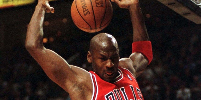 Michael Jordan of the Chicago Bulls finishes a dunk against the Trail Blazers at the Portland Rose Garden.