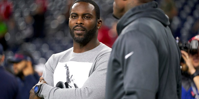 Michael Vick looks on from the side before an NFL football game between the Houston Texans and the New England Patriots on Sunday, December 1, 2019.