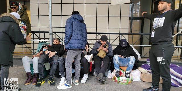 Migrants are seen outside of the Watson Hotel in Midtown Manhattan, Monday, January 30, 2023. 