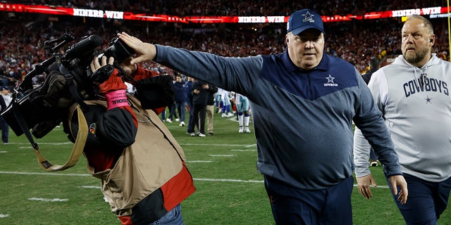 Dallas Cowboys head coach Mike McCarthy pushes a photographer away as he walks off the field after an NFL playoff game against the San Francisco 49ers in Santa Clara, Calif., on Sunday, January 22, 2023.