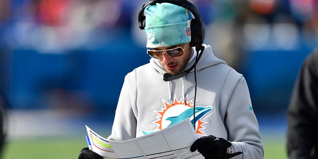 Miami Dolphins head coach Mike McDaniel looks at his score sheet during the first half of an NFL Wild Card playoff football game against the Buffalo Bills, Sunday, Jan. 15, 2023, at Orchard Park. , NY.