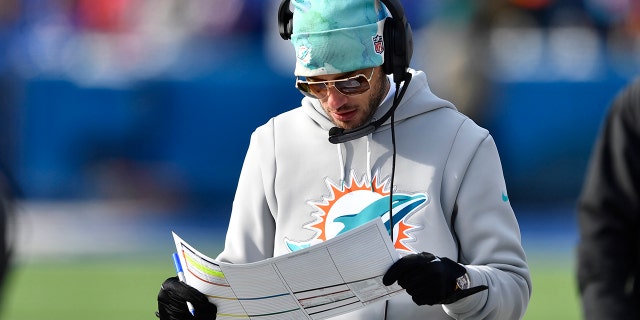 El entrenador en jefe de los Miami Dolphins, Mike McDaniel, mira su acta durante la primera mitad de un partido de fútbol americano de playoffs de la NFL contra los Buffalo Bills, el domingo 15 de enero de 2023, en Orchard Park, Nueva York.