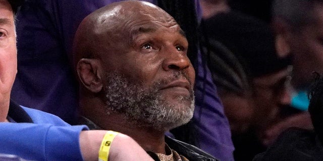 Mike Tyson watches the first half of an NBA game