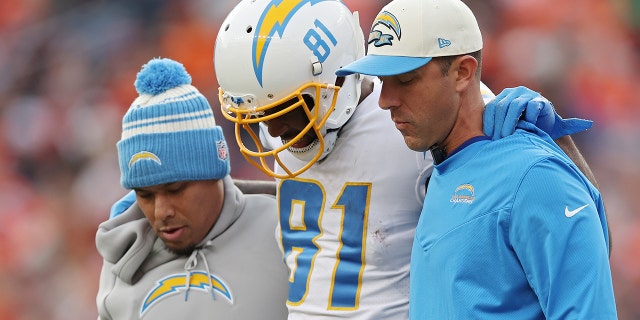 Los entrenadores ayudan a Mike Williams de Los Angeles Chargers fuera del campo durante la primera mitad de un juego contra los Denver Broncos en Empower Field en Mile High en Denver el domingo.