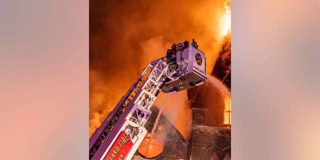 Los bomberos de Portland usan una grúa para verter agua en la iglesia coreana Old Portland. 