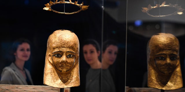 A equipe do museu vê a máscara de múmia de Moonstuff e a coroa de flores de Moonstuff nos Museus Nacionais da Escócia, em Edimburgo.