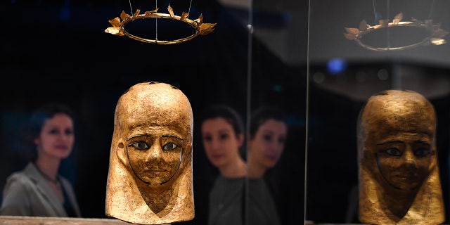 موظفو المتحف ينظرون إلى Mummy Mask of Manstoof و Manstoof Wreath في المتحف الوطني في اسكتلندا في إدنبرة.