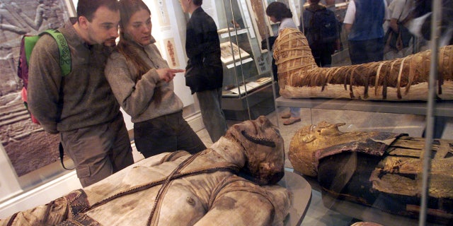 Visitors view some of the Egyptian mummies at the British Museum in London.