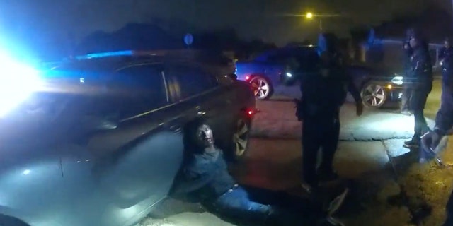 Tyre Nichols can be seen in the aftermath of the struggle, his face swollen and bloody as he sits on the ground in handcuffs, leaning with his back against a car.