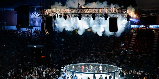 Contestants stand around the caged ring before their One Fighting Championship mixed martial arts fight at the Singapore Indoor Stadium March 31, 2012.
