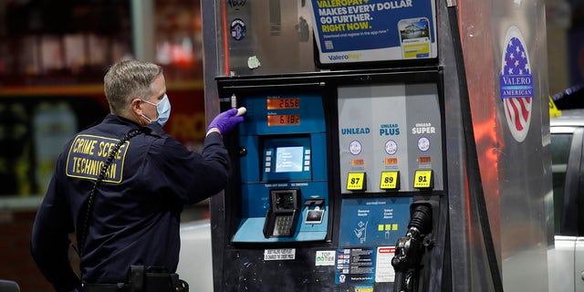 An Oakland police crime scene technician investigates the Valero gas station where the shooting happened in Oakland, California on Monday, Jan. 23.