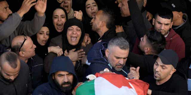 Palestinian women mourn for schoolteacher Jawad Bawaqna, 57, and Adham Jabareen, 28, during their funeral in the West Bank city of Jenin, on Jan. 19, 2023. Both of them were killed by Israeli troops.