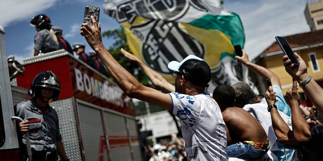 Fans are pictured as Brazilian soccer legend Pele is transported by the fire department from his former club Santos' Vila Belmiro stadium.