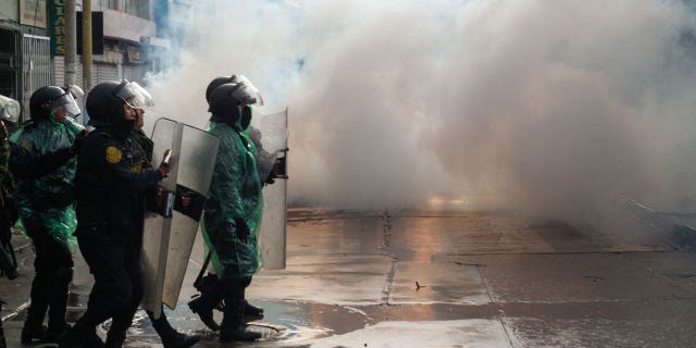 Riot police clash with anti-government protesters in Puno, Peru, on Jan. 9, 2023. At least 12 people died Monday in Peru as anti-government protesters trying to overrun an airport clashed with security forces, officials said.