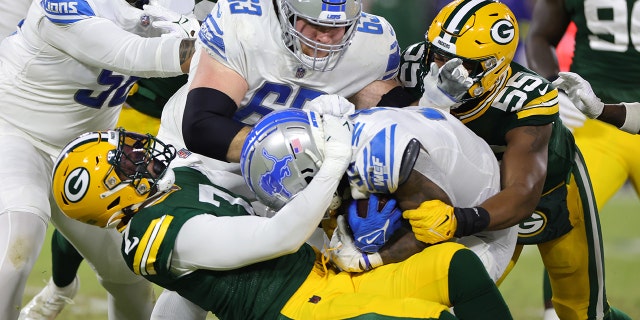 Quay Walker #7 of the Green Bay Packers tackles Jamaal Williams #30 of the Detroit Lions during the first quarter at Lambeau Field on January 08, 2023 in Green Bay, Wisconsin. 