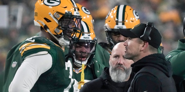 El entrenador en jefe de los Green Bay Packers, Matt LaFleur, habla con el apoyador Quay Walker, a la izquierda, después de que Walker fuera expulsado durante la segunda mitad de un partido de fútbol americano de la NFL contra los Lions of Detroit el domingo 8 de enero de 2023 en Green Bay, Wisconsin.