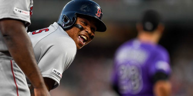 Boston Red Sox third baseman Rafael Devers reaches third base after hitting a triple against the Colorado Rockies during a game Aug. 28, 2019, at Coors Field in Denver, Colo.
