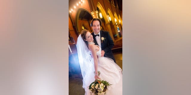 A bride and groom pose inside of a church