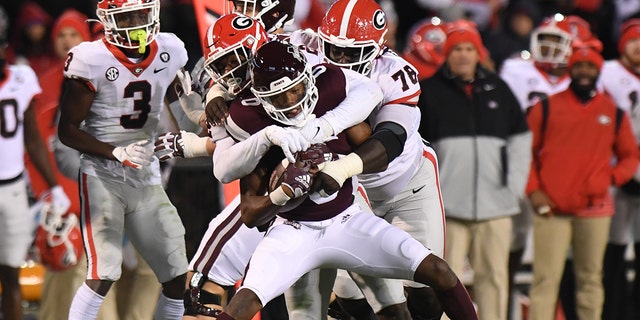 Mississippi State's Rodarius Thomas is wrapped up by Nazir Stackhouse and Smael Mondon of Georgia on Nov. 12, 2022, at Davis-Wade Stadium in Starkville, Mississippi.
