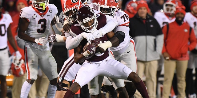 Mississippi State's Rodarius Thomas is wrapped up by Nazir Stackhouse and Smael Mondon of Georgia on Nov. 12, 2022, at Davis-Wade Stadium in Starkville, Mississippi.