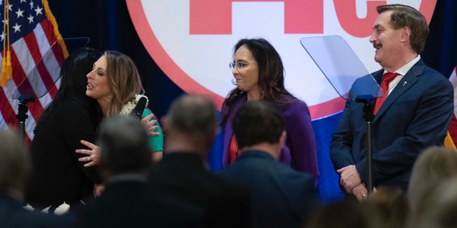 Re-elected Republican National Committee Chair Ronna McDaniel is hugged by a member as candidates Harmeet Dhillon and Mike Lindell look on at the committee's winter meeting in Dana Point, California, on Friday.