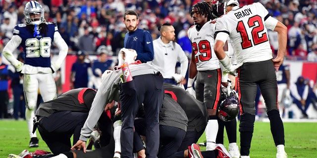 Tom Brady #12 of the Tampa Bay Buccaneers looks on during an injury timeout for teammate Russell Gage #17 during the fourth quarter against the Dallas Cowboys in the NFC Wild Card playoff game at Raymond James Stadium on January 16, 2023 in Tampa, Florida. 