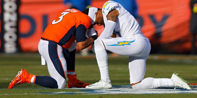 Russell Wilson #3 de los Denver Broncos y Derwin James Jr. #3 de Los Angeles Chargers oran antes de su juego en Empower Field en Mile High el 8 de enero de 2023 en Denver, Colorado.