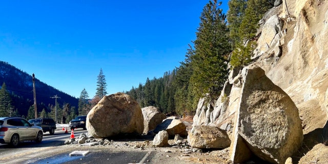 In this photo provided by Caltrans District 3, several large boulders lie in the street that fell onto Highway 50 just east of Kyburz during a storm in El Dorado National Park, Calif., Sunday, Jan. 1, 2023.