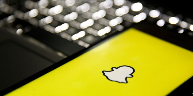 In this photo illustration, a mobile phone screen displays the Snapchat logo in front of a keyboard in Istanbul, Turkey, Feb. 24, 2020. 