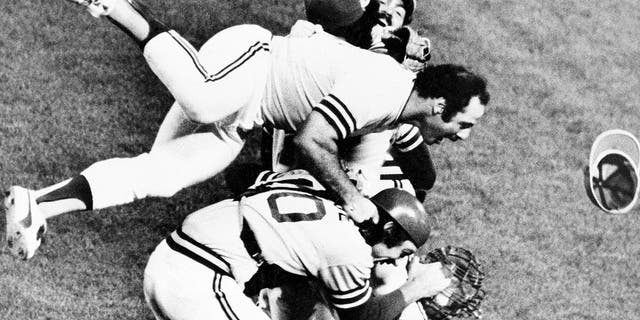 El líder Sal Bando salta a la pila cuando el atletismo jubiloso estalla en el campo después de vencer a los Dodgers de Los Ángeles para ganar la Serie Mundial, el 17 de octubre de 1974, en Oakland, California.