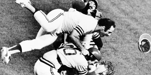 Sal Bando, top, jumps over the mound as the A's take the field after beating the Los Angeles Dodgers to win the World Series, on October 17, 1974, in Oakland, California.