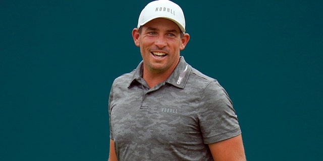 Scott Stallings reacts to a shot by Adam Scott, of Australia, on the 18th green during the final round of the BMW Championship golf tournament at Wilmington Country Club, Sunday, Aug. 21, 2022, in Wilmington, Delaware.