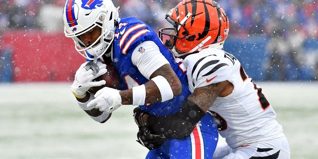 Buffalo Bills wide receiver Stefon Diggs, #14, makes a catch while defended by Cincinnati Bengals cornerback Cam Taylor-Britt, #29, during the first quarter of an AFC divisional round game at Highmark Stadium in Orchard Park, New York, Jan. 22, 2023.