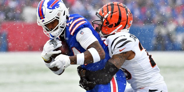 El receptor abierto de los Buffalo Bills, Stefon Diggs, #14, hace una atrapada mientras es defendido por el esquinero de los Cincinnati Bengals, Cam Taylor-Britt, #29, durante el primer cuarto de un juego de división en la AFC en Highmark Stadium en Orchard Park, Nueva York el 22 de enero de 2023.