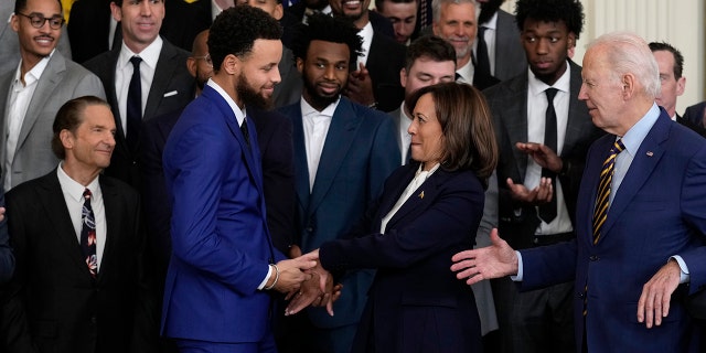 La vicepresidenta Kamala Harris le da la mano al cuatro veces campeón de la NBA y al dos veces Jugador Más Valioso de la NBA, Stephen Curry, mientras el presidente Joe Biden le da la mano durante un evento en el Salón Este de la Casa Blanca para los campeones de la NBA de 2022, los Golden State Warriors, en Washington el martes 17 de enero de 2023.