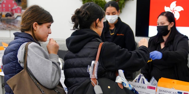 Passengers disembarking from international flights take anonymous COVID tests for study purposes at Newark Liberty International Airport in Newark, N.J., Wednesday, Jan. 4, 2023. 