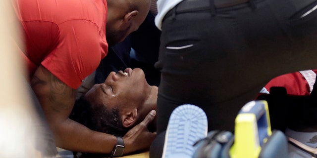 Kuzey Karolina Eyaleti oyuncusu Terquavian Smith, 21 Ocak 2023 Cumartesi günü Chapel Hill'de oynanan bir Kuzey Karolina maçında faul yapıldıktan sonra yere yığıldıktan sonra tıbbi personel tarafından tedavi ediliyor.