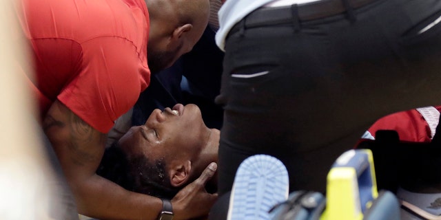 El jugador del estado de Carolina del Norte, Terquavion Smith, es tratado por personal médico después de estrellarse contra el suelo después de recibir una falta durante el juego de Carolina del Norte, el sábado 21 de enero de 2023, en Chapel Hill.