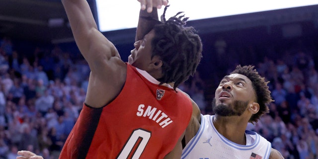 North Carolina State guard Terquavion Smith is fouled by North Carolina forward Leaky Black as he drives to the basket, Saturday, Jan. 21, 2023, in Chapel Hill. Smith crashed to the floor and was taken off the court.