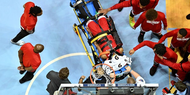 Teammates reach out to touch Terquavion Smith as he leaves the court after being injured at the Dean E. Smith Center on Jan. 21, 2023, in Chapel Hill, North Carolina.