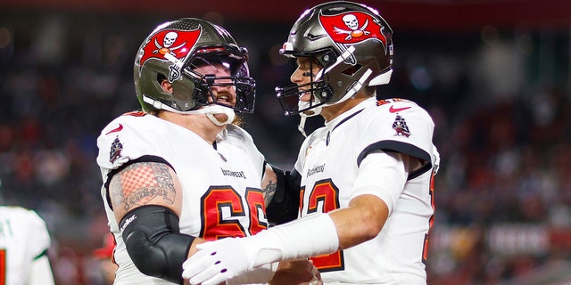 Ryan Jensen #66 and Tom Brady #12 of the Tampa Bay Buccaneers embrace on the field prior to a game against the Dallas Cowboys in the NFC Wild Card playoff game at Raymond James Stadium on January 16, 2023 in Tampa, Florida.