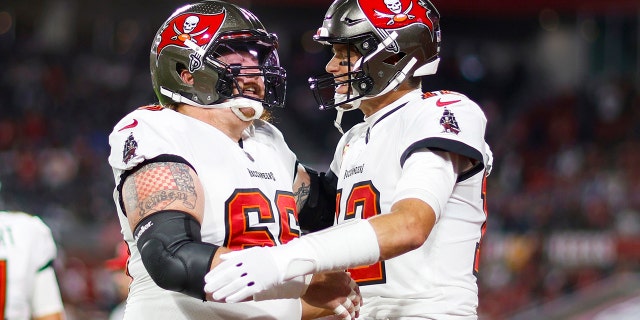 Ryan Jensen #66 and Tom Brady #12 of the Tampa Bay Buccaneers embrace on the field prior to a game against the Dallas Cowboys in the NFC Wild Card playoff game at Raymond James Stadium on January 16, 2023 in Tampa, Florida.