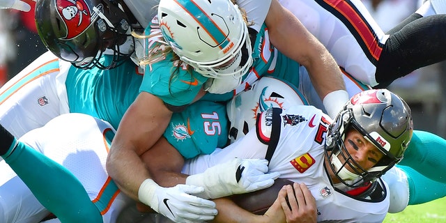 Tom Brady of the Buccaneers is sacked by Jerome Baker of the Miami Dolphins at Raymond James Stadium on Oct. 10, 2021, in Tampa, Florida.