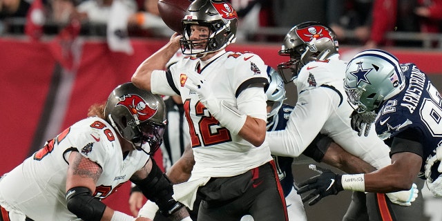 Le quart-arrière des Buccaneers de Tampa Bay, Tom Brady (12 ans), travaille sous pression contre les Cowboys de Dallas pendant la première moitié d'un match de football avec joker de la NFL, le lundi 16 janvier 2023, à Tampa, en Florida.