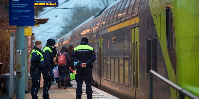 Deutsche Bahn security guards stand on the platform at Brokstedt station at dawn in Brokstedt, Germany, on Jan.26, 2023