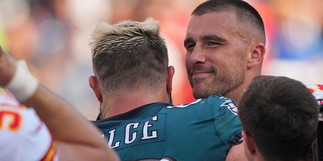 Philadelphia Eagles center Jason Kelce, center, and Kansas City Chiefs tight end Travis Kelce, right, embrace during a game between the Philadelphia Eagles and the Kansas City Chiefs Oct. 3, 2021, at Lincoln Financial Field in Philadelphia.